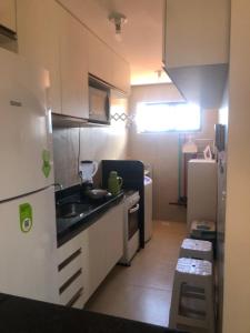 a small kitchen with a sink and a refrigerator at Nice apartment Bessa beach in João Pessoa