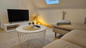 a living room with a tv and a table at AS5 Two Hallstadt - Gäste-Favorit - Modern, Ruhig & 5 Min zum Zug nach Bamberg - BeMa Apartments in Hallstadt
