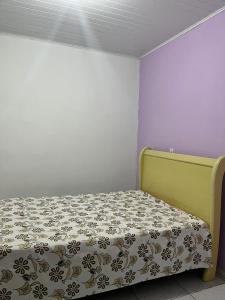 Dormitorio pequeño con cama con colcha de flores en Sítio em Marimbondo, en Marimbondo