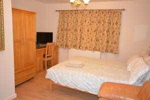 a small bedroom with a bed and a desk at Large Ensuite room in Oxford