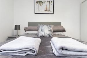 ein Schlafzimmer mit 2 Betten und Handtüchern darauf in der Unterkunft Exquisite stays, modern apartment in city centre in Coventry
