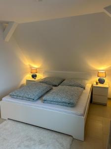 1 dormitorio con 1 cama blanca y 2 lámparas en FeWo AS 5 One Bamberg, en Hallstadt
