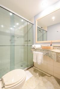 uma casa de banho com uma cabina de duche em vidro e um WC. em Luxy room Brooklin-WTC em São Paulo