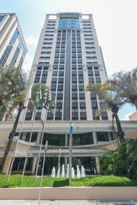 um edifício alto com uma fonte em frente em Luxy room Brooklin-WTC em São Paulo