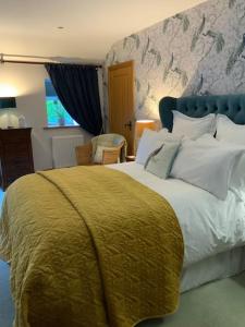 a bedroom with a large bed with a yellow blanket at Bees cottage Luxury 5* Holiday cottage with Hot Tub in Scarborough