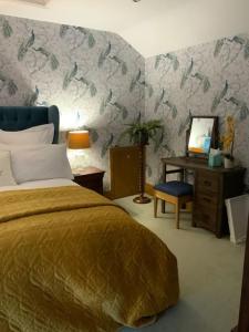 1 dormitorio con cama y escritorio con espejo en Bees cottage Luxury 5* Holiday cottage with Hot Tub, en Scarborough