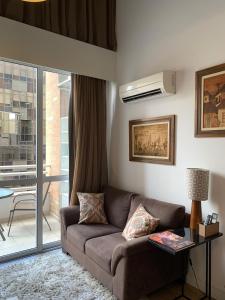 d'un salon avec un canapé et un balcon. dans l'établissement Charm Duplex - Nyc Berrini - Próximo WTC, à São Paulo