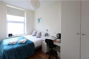 a bedroom with a bed and a desk and a window at Comfort Bedrooms near Euston - 161/2 in London