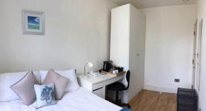 a bedroom with a bed and a desk with a computer at Comfort Bedrooms near Euston - 161/2 in London