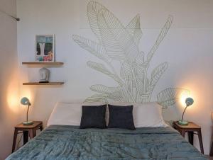 Pahoa的住宿－Eco-Farm Self-Contained Studio，卧室配有一张床铺,墙上挂着一个大植物壁画