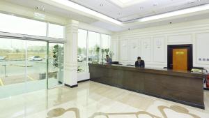 two people standing at a reception desk in a lobby at Muscat International Hotel Plaza in Salalah