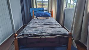 małe łóżko w pokoju z oknem w obiekcie Brisbane Budget Homestay w mieście Brisbane