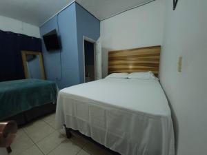Schlafzimmer mit einem großen weißen Bett und blauen Wänden in der Unterkunft Apart Eco Estudio Joocah in Trujillo