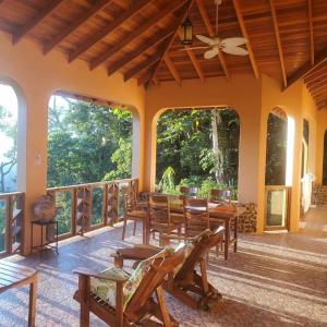 a room with wooden tables and chairs on a balcony at La Hacienda Belize Guest House in Benque Viejo del Carmen