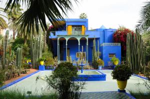 un edificio azul con una piscina frente a él en Yacout Appartement Majorelle en Marrakech