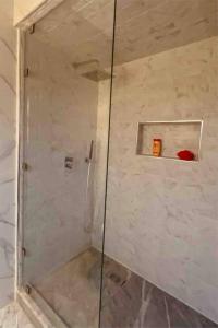 La salle de bains est pourvue d'une douche avec une porte en verre. dans l'établissement Apartment in Agadir (avenue des far ), à Agadir