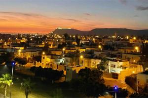 une ville de nuit avec une montagne en arrière-plan dans l'établissement Apartment in Agadir (avenue des far ), à Agadir