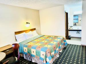 Un pat sau paturi într-o cameră la Holiday Pines Inn and Suites