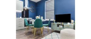 a dining room with blue walls and a table and chairs at Cozy 3 Bedroom Flat in London! in London