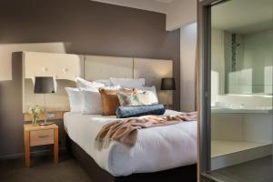 a bedroom with a large white bed with pillows at Fable Christchurch in Christchurch