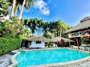 een zwembad in een resort met palmbomen bij EverGreen Cabarete in Cabarete