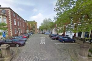 a city street with cars parked in a parking lot at Large Studio Room in City Centre (Shared Bathroom) in Preston