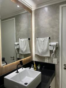 y baño con lavabo blanco y espejo. en Flat de Luxo - Porto de Galinhas - praia de Muro Alto, en Porto de Galinhas