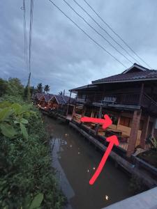 a body of water next to a group of houses at บ้านสุขใจ อัมพวา in Samut Songkhram