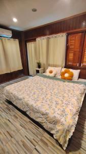 Un dormitorio con una cama grande con ositos de peluche. en บ้านสุขใจ อัมพวา, en Samut Songkhram