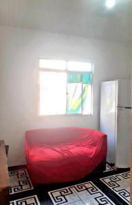 a bedroom with a red bed and a window at Casa para temporada in Salvador