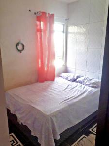 a bed in a room with a window at Casa para temporada in Salvador