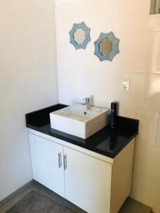 La salle de bains est pourvue d'un lavabo blanc et d'un comptoir noir. dans l'établissement Charmantes Gästehaus im Feriengebiet Ytu, Caacupé (Neubau 2022), à Caacupé