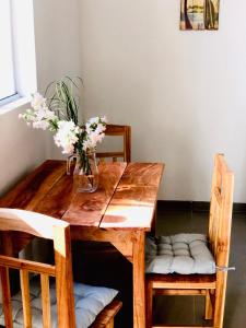 une table en bois avec un vase de fleurs. dans l'établissement Charmantes Gästehaus im Feriengebiet Ytu, Caacupé (Neubau 2022), à Caacupé