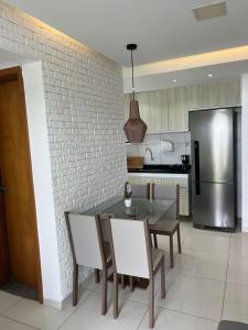 a kitchen with a table and chairs and a stainless steel refrigerator at Apartamento completo Ilheus in Ilhéus
