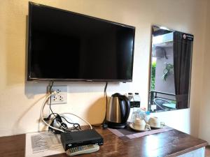 una TV a schermo piatto a parete con telecomando di The Morning mini house aonang ad Aonang Beach