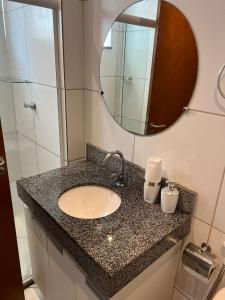 a bathroom with a sink and a mirror at Apartamento completo Ilheus in Ilhéus
