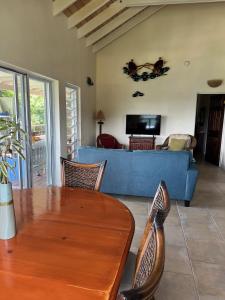 sala de estar con sofá azul y mesa en COCONUT BREEZE VILLA: MESMERIZING VIEWS, COOLING TRADEWINDS, en Coral Bay