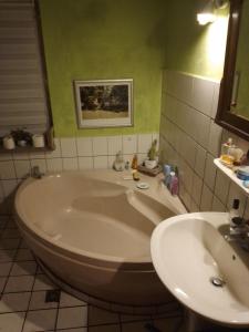 a bath tub and a sink in a bathroom at Ruhig und spartanisch Wohnen im Denkmal in Lichtenwalde