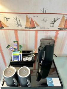 una macchinetta del caffè e tazze su un vassoio su uno scaffale di Gästehaus Weserblick am Weser-Sandstrand a Berne