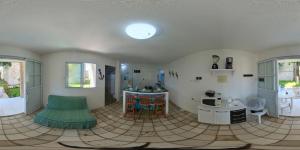 ein Wohnzimmer mit einem Tisch und einem grünen Sofa in der Unterkunft Chale 48 Maragogi Village Gales in Maragogi