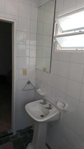 baño blanco con lavabo y ventana en Departamento para 2 personas en Bialet Massé