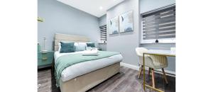 a small bedroom with a bed and a table at Sleek Modern 3BR Flat in Nunhead in London