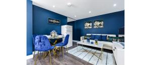 a blue living room with a couch and a table at Sleek Modern 3BR Flat in Nunhead in London +8 photos