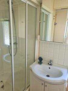 uma casa de banho com um lavatório e um chuveiro em Sunrise Holidays Skegness - Emerald em Skegness