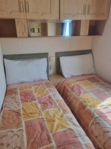 twee bedden naast elkaar in een kamer bij Sunrise Holidays Skegness - Emerald in Skegness