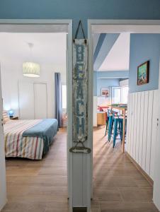 a bedroom with a bed and a dining room at CoralBlu, stylish beachside flat - Fast Wi-Fi in Armação de Pêra