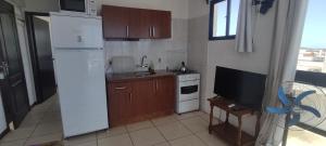 W kuchni znajduje się biała lodówka i kuchenka mikrofalowa. w obiekcie Apartamento 12 (4 personas) w mieście Punta del Diablo