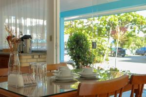 mesa de comedor con sillas y mesa de cristal en Pousada Talismã, en Florianópolis