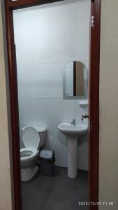 a bathroom with a toilet and a sink and a mirror at La casa de Joan in Máncora