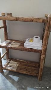 ein Holzregal mit einer Rolle Toilettenpapier darauf in der Unterkunft La casa de Joan in Máncora